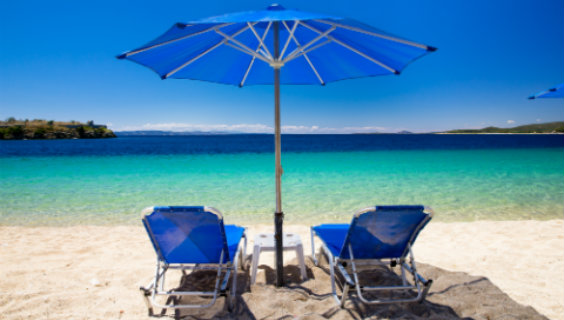 Blå strandstole på sandstrand